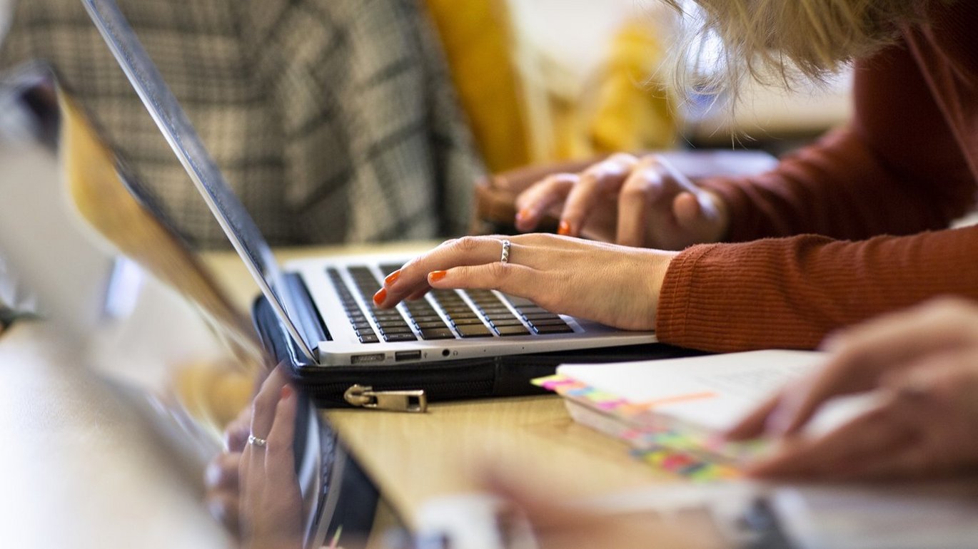 Hænder taster på tastaturet på en bærbar pc